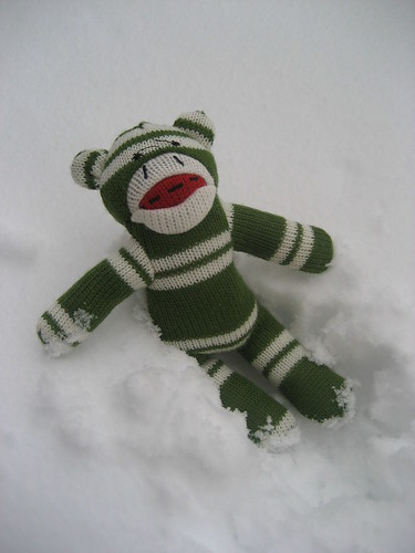 Sock monkey plays in the snow