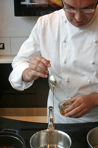 Chef Julien Bompard measuring out some honey for the cranberry confit