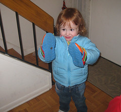 toddler with warm coat and sneakers on her hands