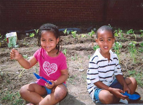 RaNiah Jones (left) and Taleeq Tate take a break from planting vegetables in their garden at the Woodlawn Learning Center in Hopewell, Va.