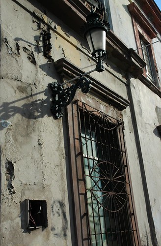 Iron gas lamp and window grate, shadows, spraypaint art, Historical district building, Mazatlan, Sinaloa, Mexico by Wonderlane