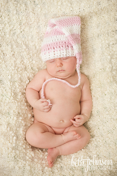 sleeping baby in pink and white elf hat
