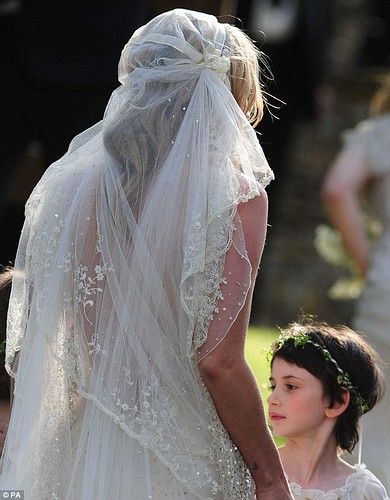  Moss's hair was styled in loose blonde waves underneath the 1920s-style cap veil with flower embroidery on the lace