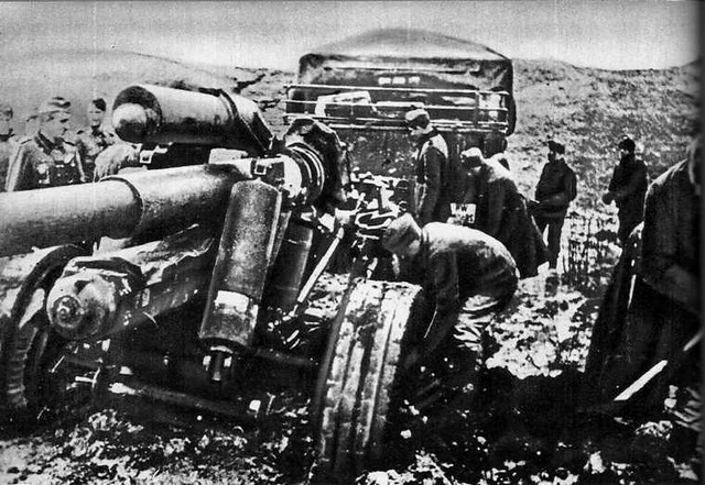 Soldados de infantaria alemã tentam desesperadamente tirar de seu acampamento as grandes peças de artilharia afundadas até os eixos.