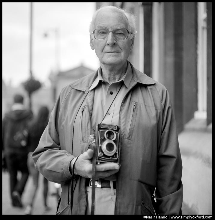 A photographer holding a Rolleicord film camera