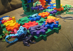 colorful rubber/plastic frogs and snakes on and around a system of colorful gears