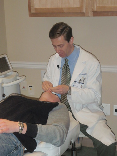 Dr. Adam Sobel prepares the patient's face for an Isolaz acne laser treatment demonstration by CosmopolitanSkinCareSolutions