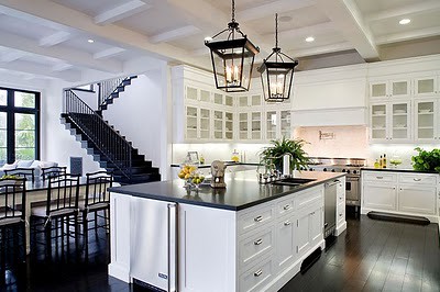 meridith_baer_spanish_style_house_home_kitchen_white_cabinetry_glass_front_uppers_island_dark_wood_floors_black_counters_countertops