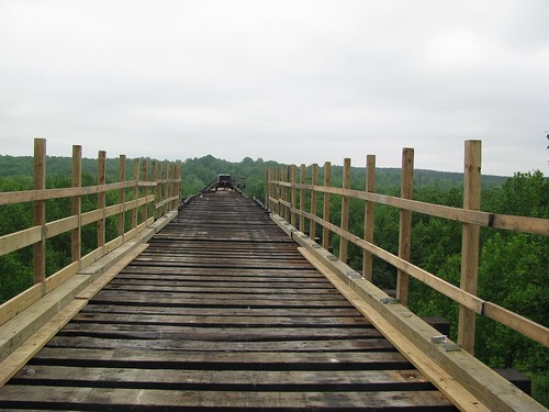 Five foot high wooden hand rails are installed on the bridge.