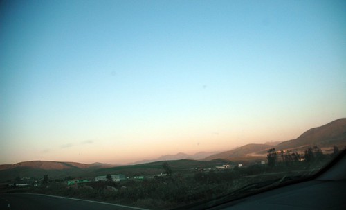 Driving into Mexico, just across the border, as the sun sets orange and blue, landscape, Mexico by Wonderlane
