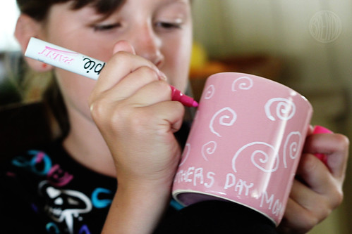 child coloring a cup