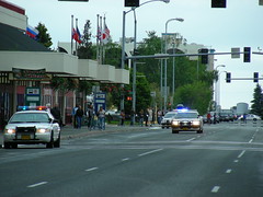 Police cars speed past the Transit Center