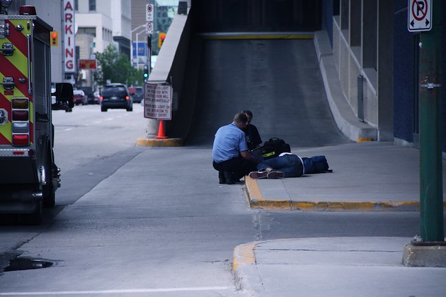 Walking near the Winnipeg Convention Centre, I spotted two EMS responders checking the vitals of someone who appears to have passed out on the street due to drugs or alcohol.