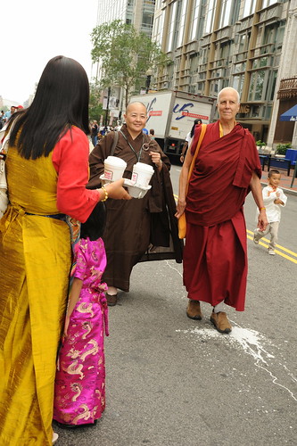 Happiness: Tibetan woman and child in silk chubas carry coffee, a nun and a monk in robes walk in the Happy Birthday to His Holiness the Dalai Lama parade, a Tibetan boy in traditional clothes, Tibetans at Kalachakra, Washington D.C., USA by Wonderlane