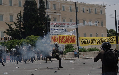 Greek riot police throwing tear gas cannister at protesters. Syntagma Square, Athens