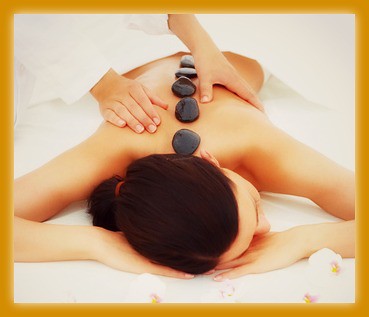 Beautiful woman receiving hotstone massage at spa