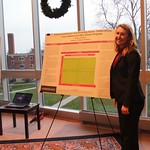 Student poses with her poster presentation.