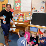 A student giving her preschoolers treat bags