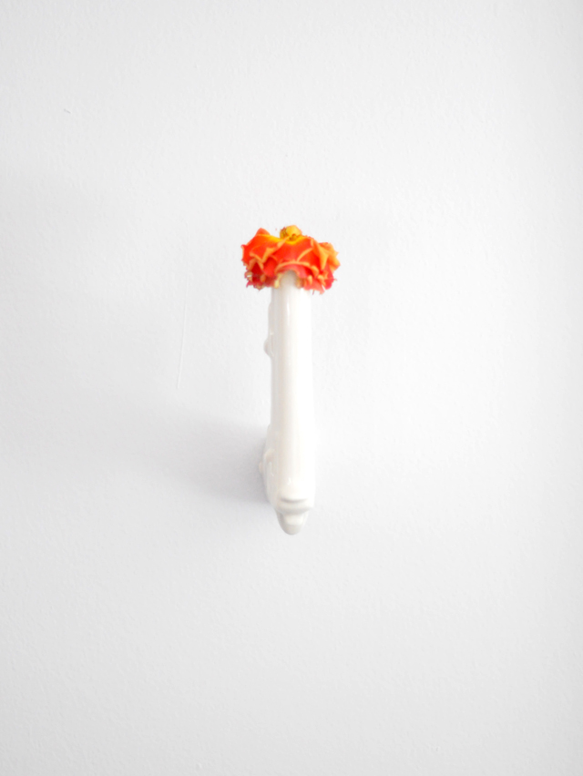 gun vase with wilted rose   