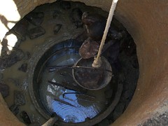 Man puts stones into a collapsed area of the well