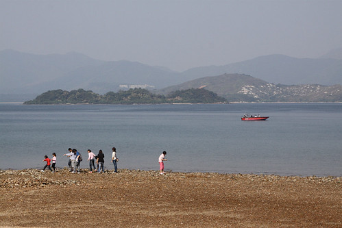 Children walk along the rocky beach at Wu Kai Sha