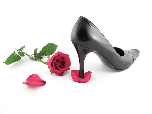 A stiletto high heel crushing a rose petal