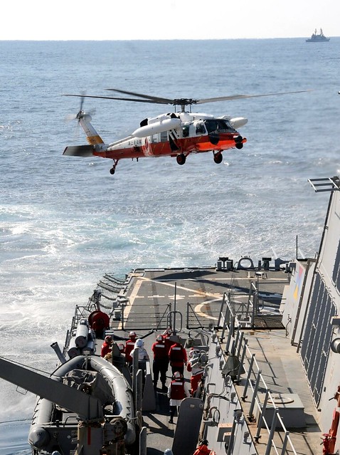 Japan coast guard helicopter prepares to land aboard USS Fitzgerald.