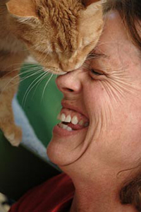 Woman getting a kiss from an orange tabby cat