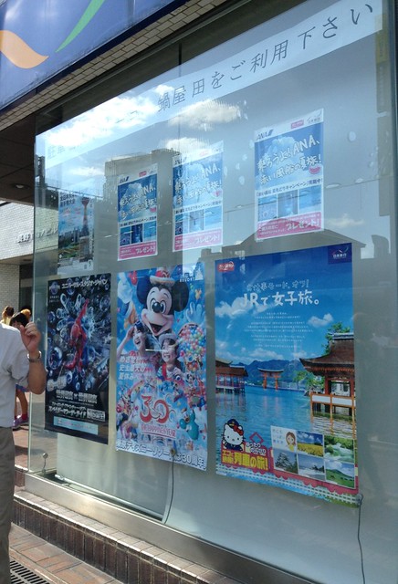 通りの旅行会社には、東京ディズニーランド30周年のポスターが。｜長野びんずる