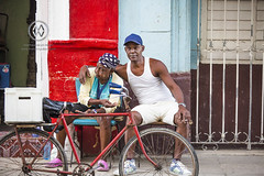 A mother and adult son sit on the street.